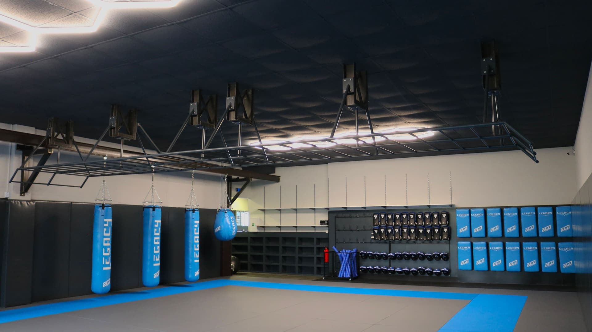 Mattenfläche der Grappling-Halle in Pinneberg mit Sandsäcken, Calisthenics-Konstruktion und Ausrüstungswand